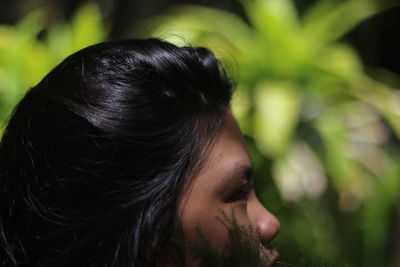 Cropped image of young woman looking away at park