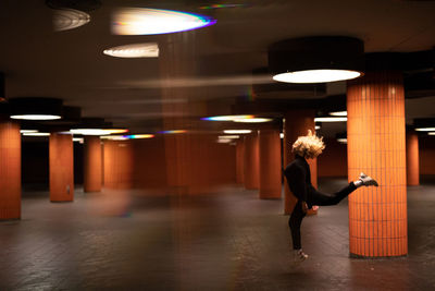 Woman jumping in illuminated garage