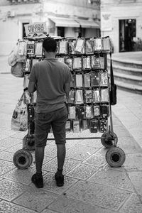 Rear view of young man standing at market stall