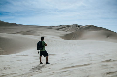 Rear view of man on sand dune