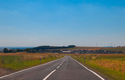 Empty road along countryside landscape