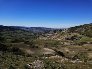 Scenic view of mountains against clear blue sky