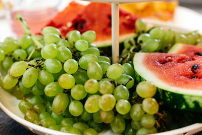 Plate with grapes and watermelon on the festive table horizontal close-up