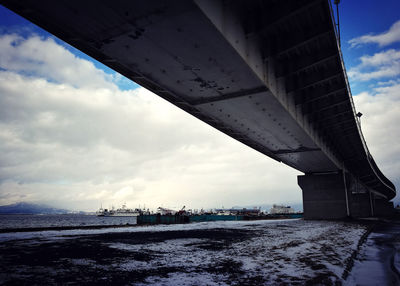 Low angle view of bridge over sea against sky