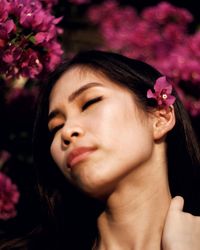 Close-up portrait of woman with pink flower