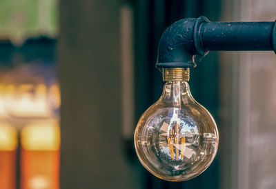 Close-up of light bulb hanging from faucet