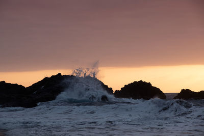 Sunset at bollullo beach at tenerife island with huge breaking waves.