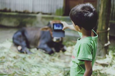 Rear view of woman photographing through camera