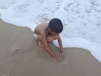 High angle view of shirtless boy on beach