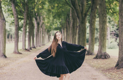 Young woman wearing dress standing in park