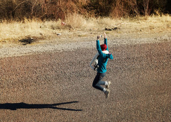 Full length of jumping child on shadow