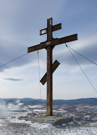 Cross on sea against sky