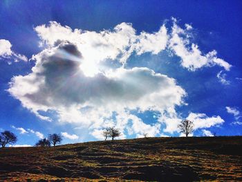 Scenic view of field against cloudy sky