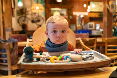 Portrait of cute boy sitting on table