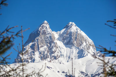 Snow covered mountain against clear blue sky