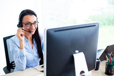 Smiling female call center worker with headset 