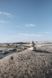 Surface level of stones on beach against sky