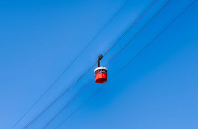 Low angle view of electricity pylon against clear blue sky