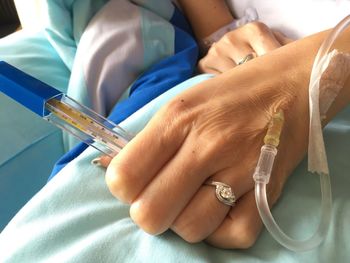 Cropped hand of woman with iv drip in hospital