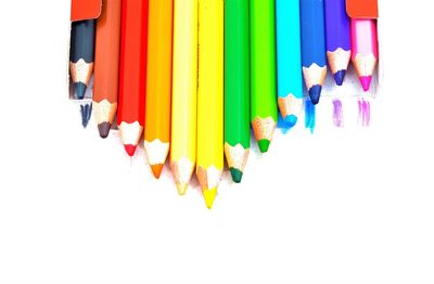 High angle view of colored pencils against white background