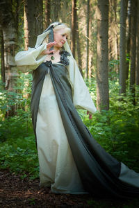 Portrait of woman in traditional clothing standing in forest