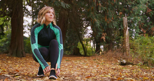 Portrait of young woman sitting in forest