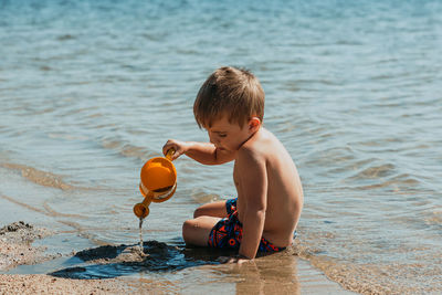 Side view of boy playing with balloons