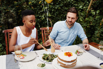 Couple enjoying food during birthday celebration