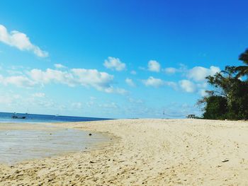 Scenic view of beach against blue sky