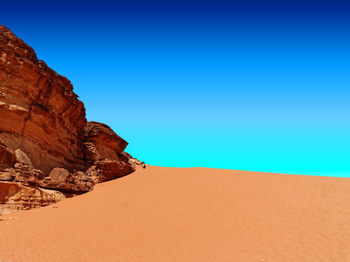 Scenic view of desert against clear blue sky