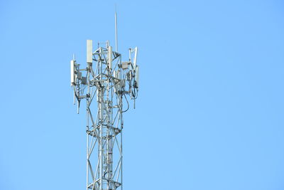 Low angle view of communications tower against clear blue sky