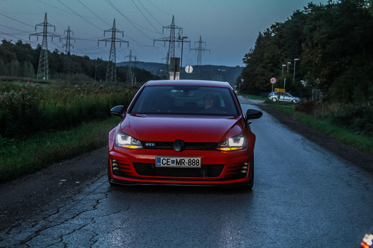 transportation, mode of transportation, road, land vehicle, motor vehicle, car, city, street, on the move, motion, nature, electricity, no people, tree, dusk, the way forward, red, travel, architecture, outdoors