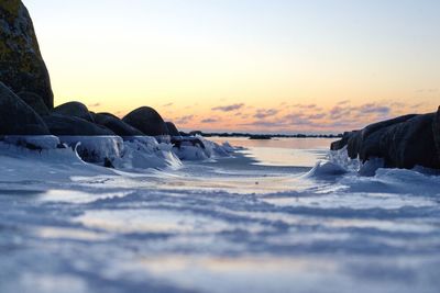 Scenic view of frozen sea against sky during sunset