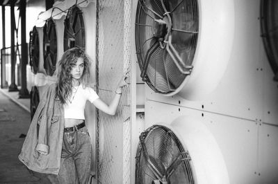 Portrait of teenage girl standing against exhaust fans