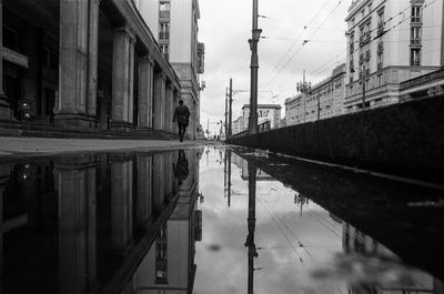 Reflection of buildings in puddle on street
