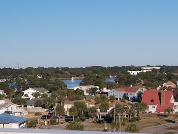 Houses in town against clear blue sky