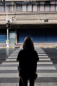 Rear view of woman crossing road