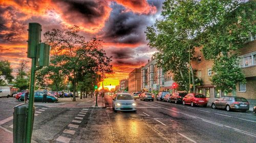 Cars moving on city street during sunset