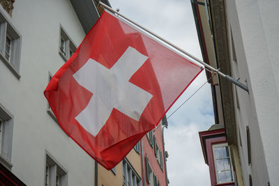 Low angle view of flag against buildings in city