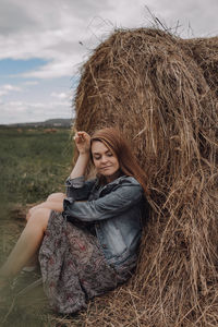 Portrait of smiling young woman sitting on field