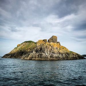 Rock formations in sea against sky