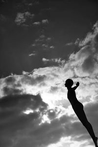 Low angle view of silhouette people against cloudy sky