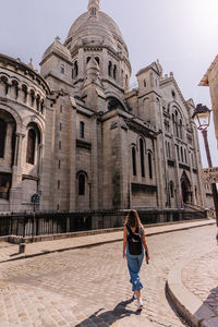 Full length of woman outside building against sky