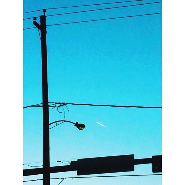 low angle view, power line, clear sky, cable, street light, electricity, blue, transfer print, lighting equipment, silhouette, power supply, pole, sky, auto post production filter, power cable, connection, built structure, electricity pylon, technology, architecture