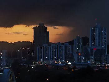 Illuminated buildings in city against sky at night