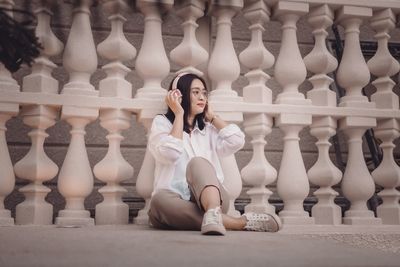 Low section of young woman standing by fence