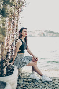 Young woman sitting on rock at beach