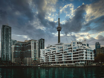 Modern buildings in city against cloudy sky