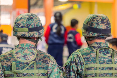 Rear view of soldiers standing indoors