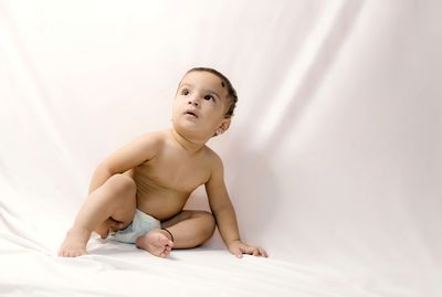 Cute baby girl sitting on bed